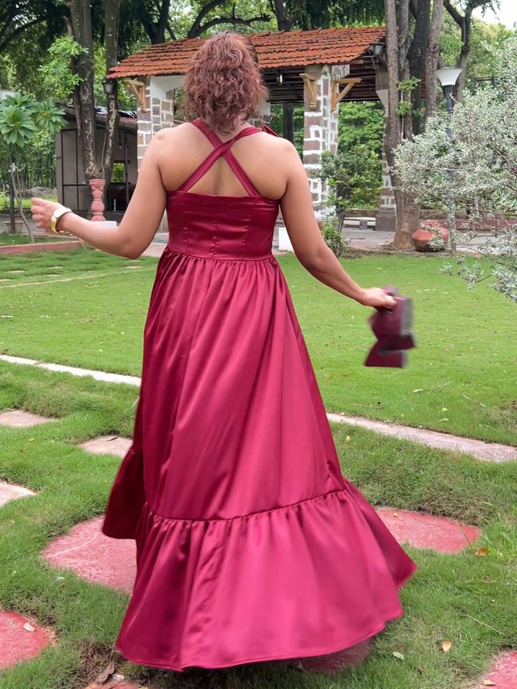 Person wearing a red dress with a garden background