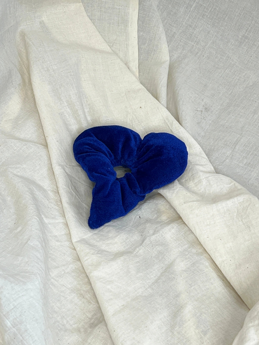 Blue scrunchie on a white fabric background