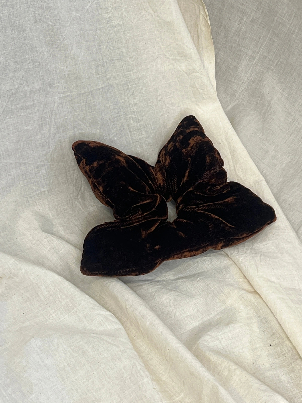 Brown scrunchie on a white fabric background