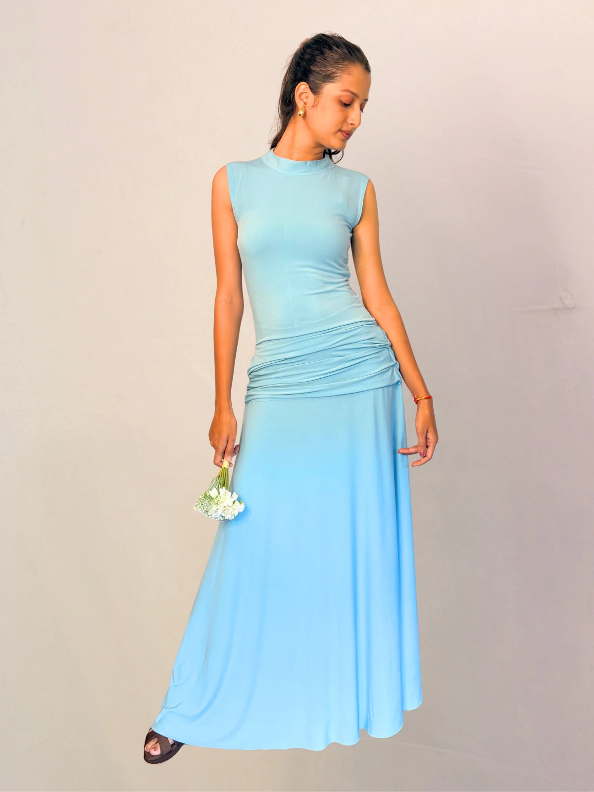 Woman wearing a light blue dress against a plain background