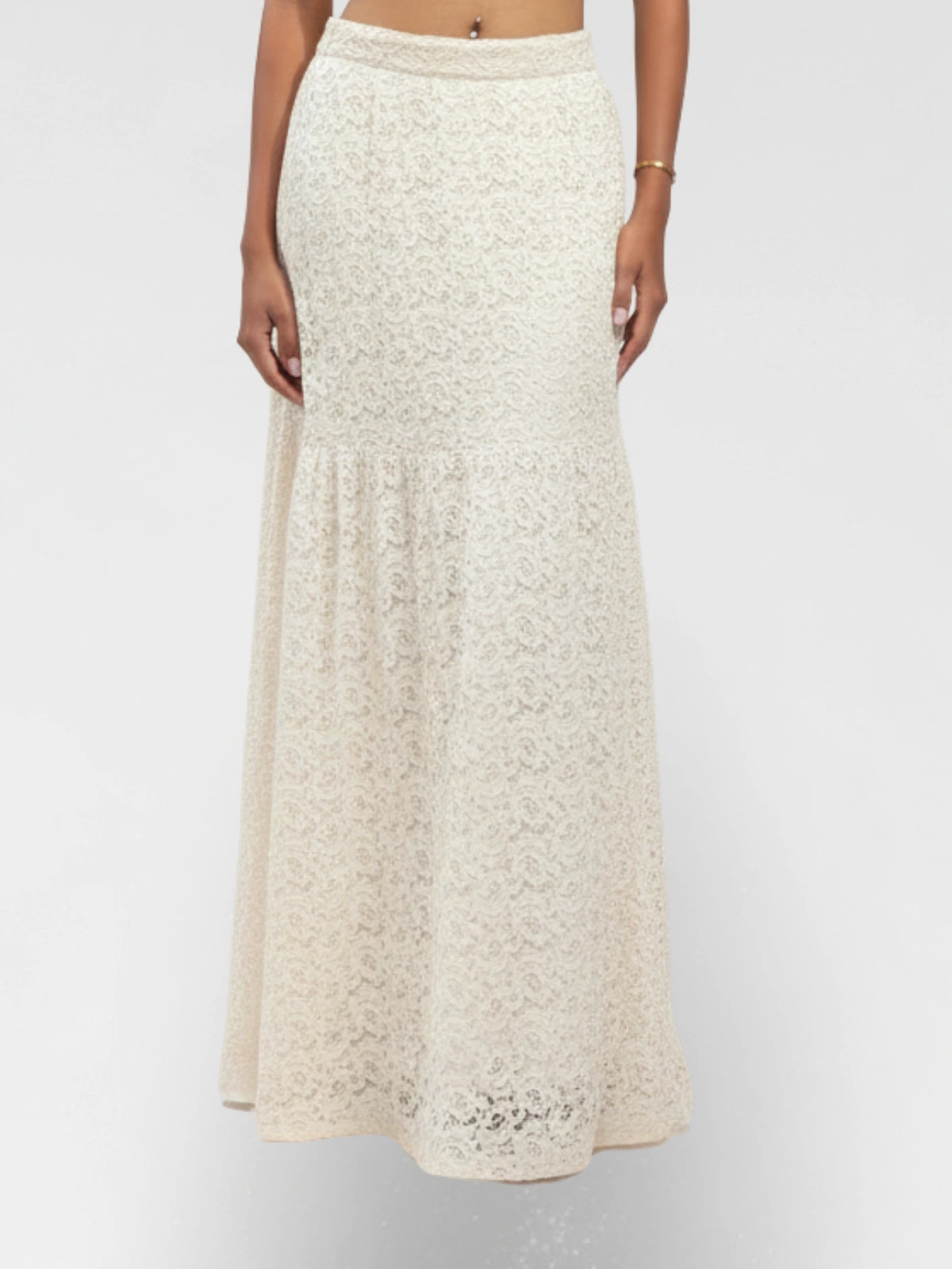 Beige lace skirt worn by a person on a white background