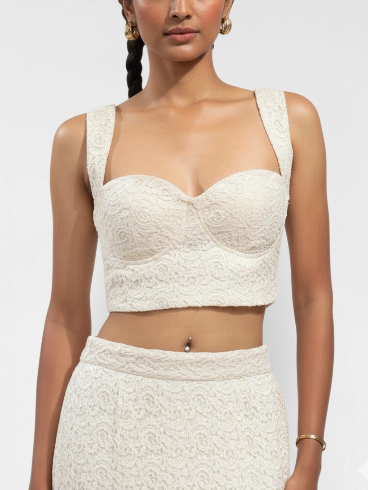 Woman wearing a white lace top and skirt on a plain background