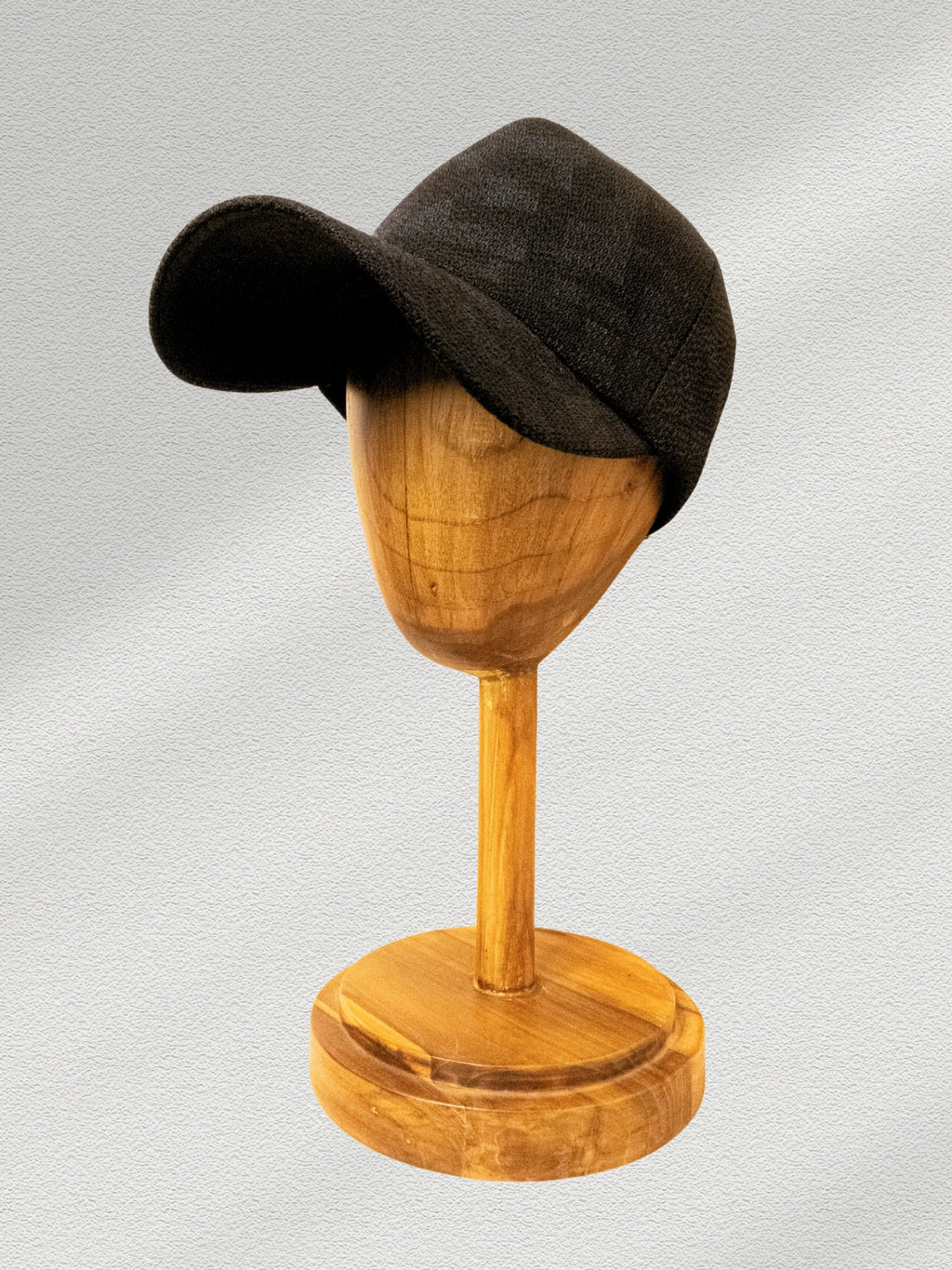 Brown hat on a wooden mannequin head against a light gray background