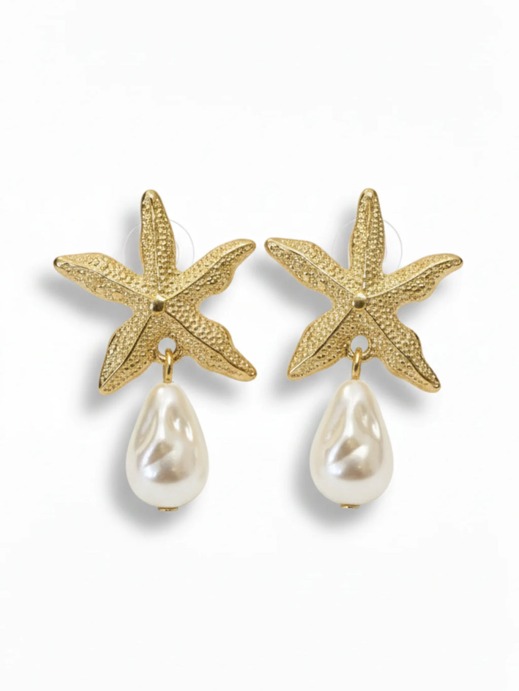 Gold starfish earrings with pearl drops on a white background