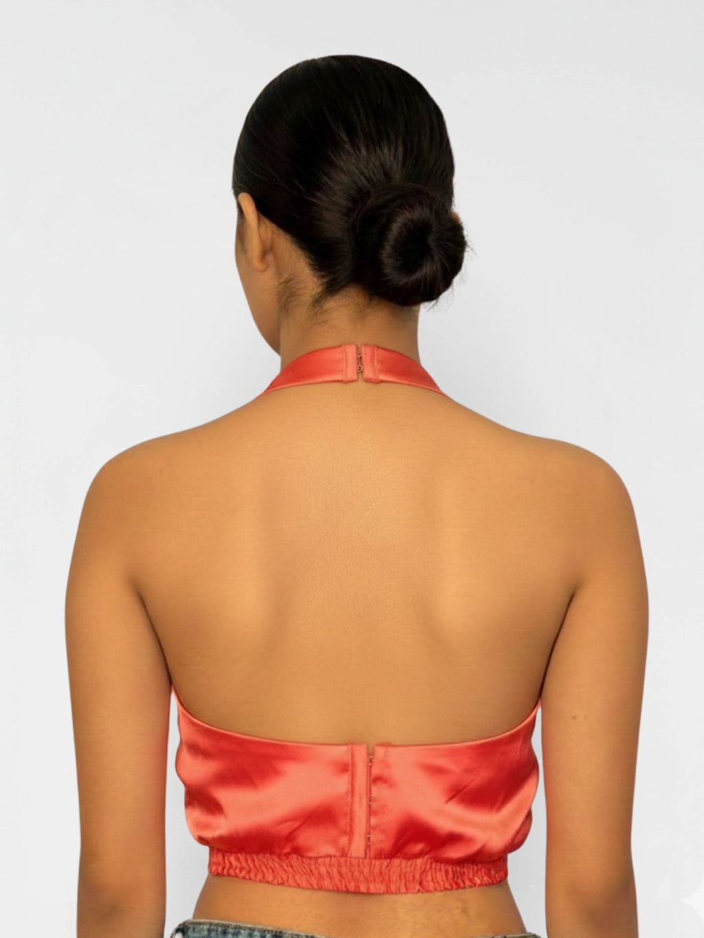 Person wearing a red satin top with a plain background