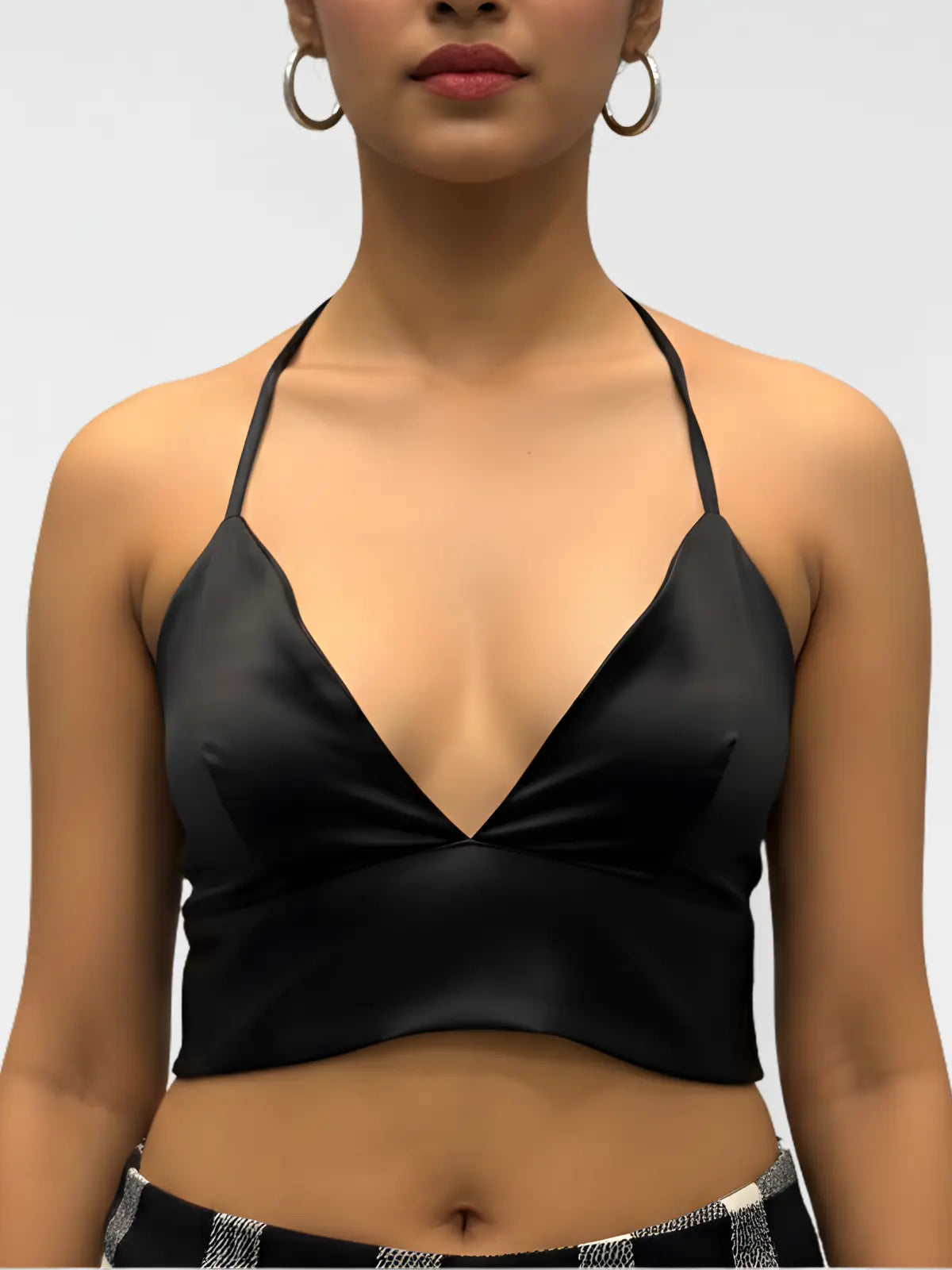 Black satin top worn by a model on a plain background