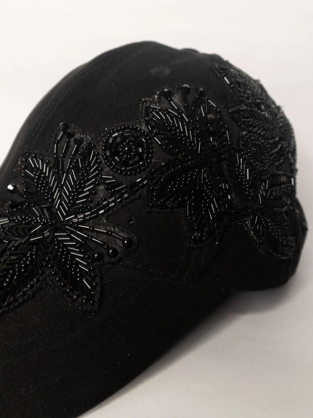 Black beaded flower cap on a white background