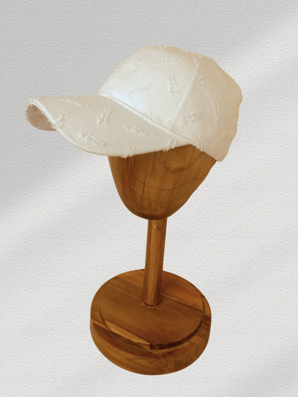 White cap on a wooden display stand against a light gray background