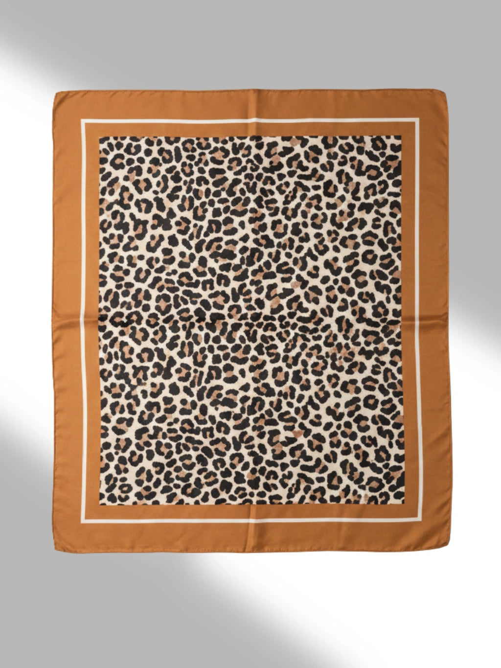 Leopard print scarf with brown border on a light gray background