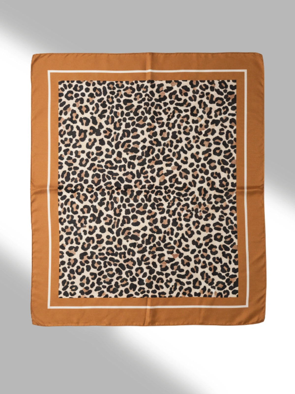 Leopard print scarf with brown border on a light gray background