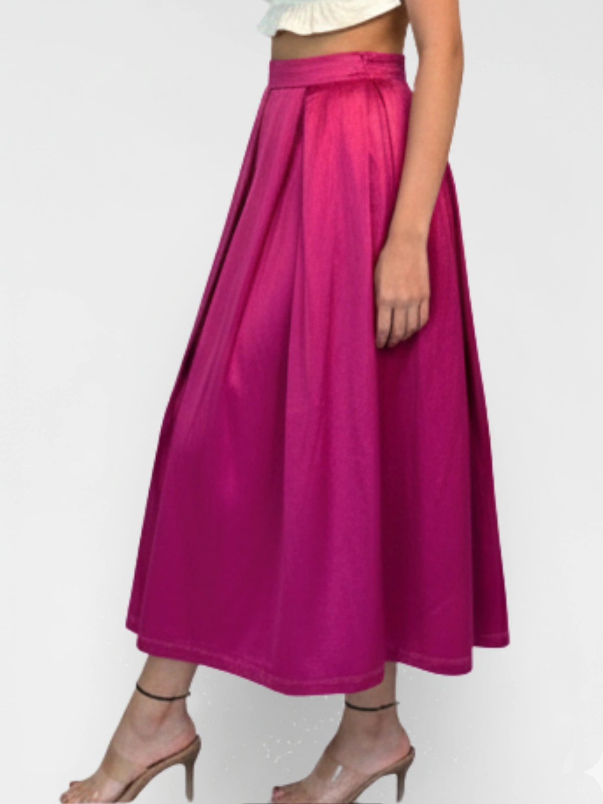 Person wearing a bright pink skirt on a plain background