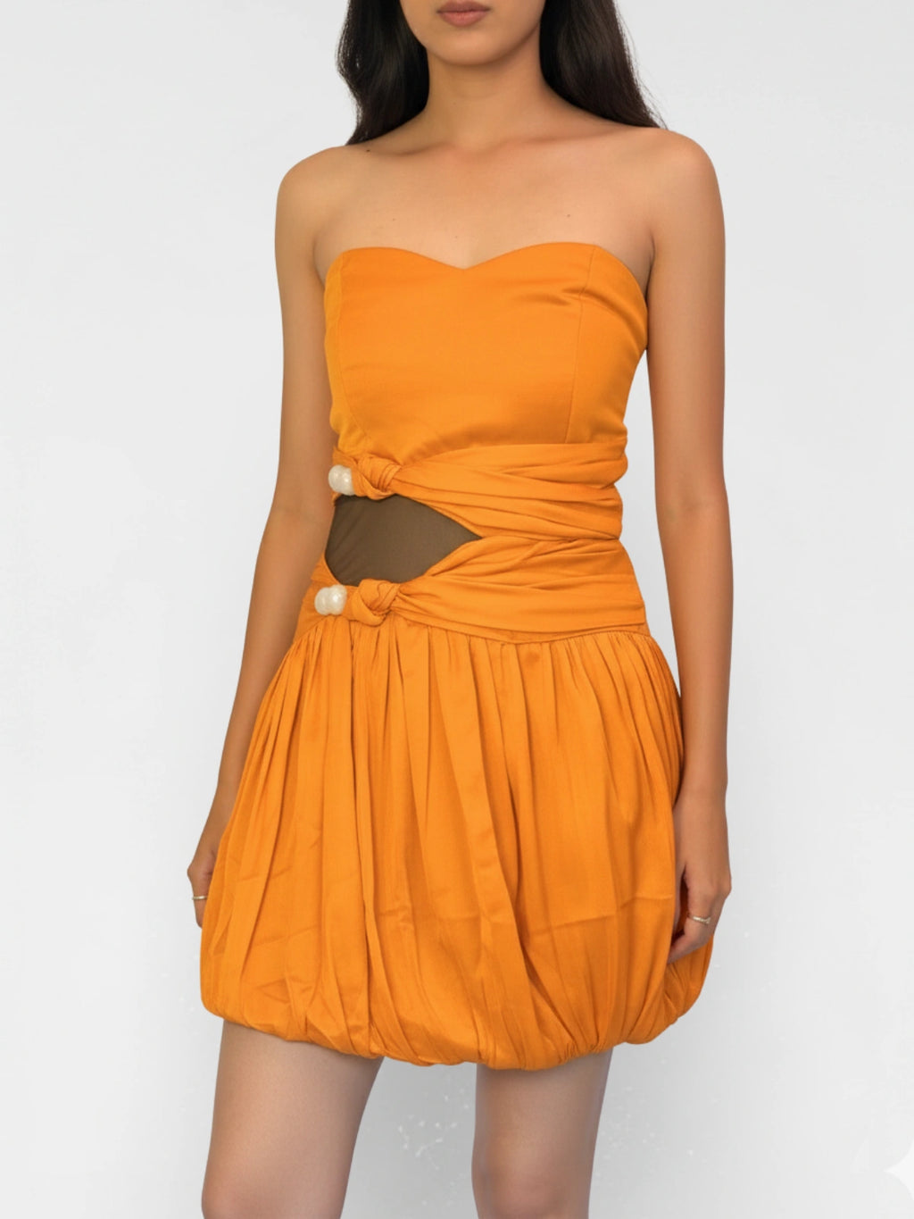 Orange strapless dress with cut-out design on a white background
