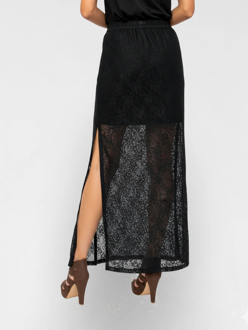 Black lace skirt with a high slit worn by a person on a white background