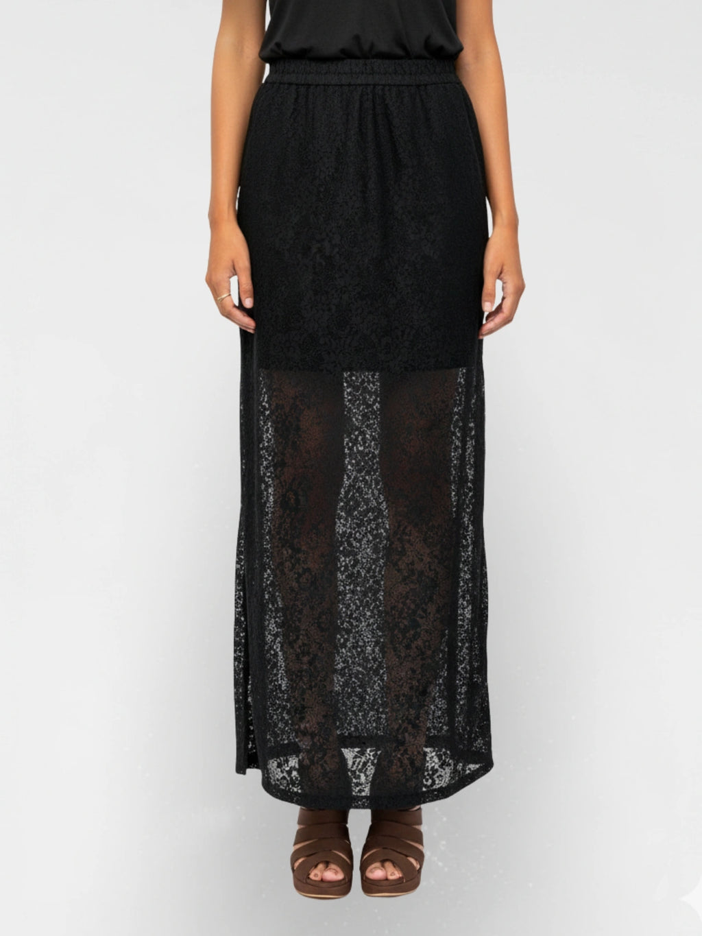 Black lace skirt worn by a person on a white background