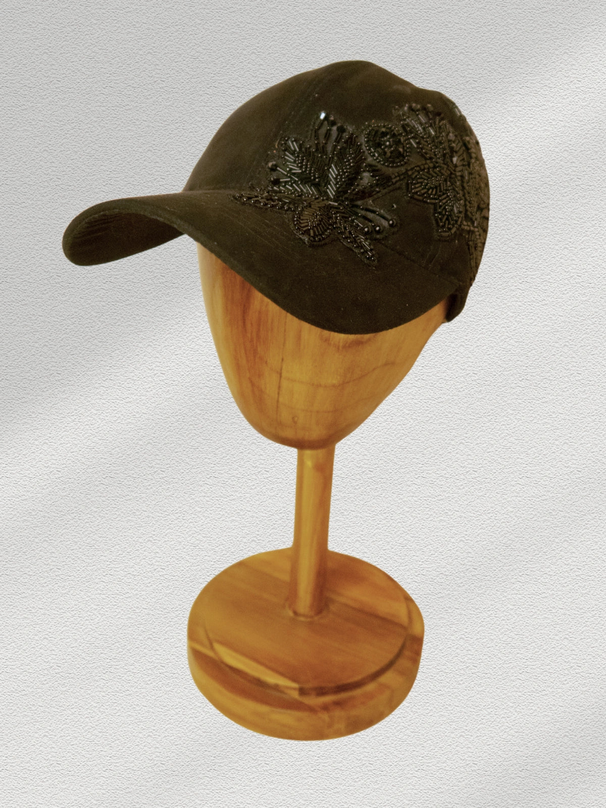 Brown cap on a wooden mannequin head against a light gray background