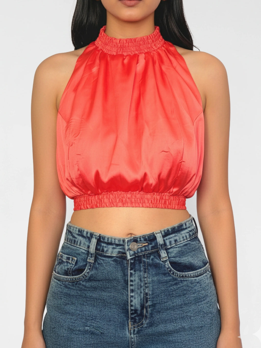 Person wearing a coral halter top and blue jeans on a white background