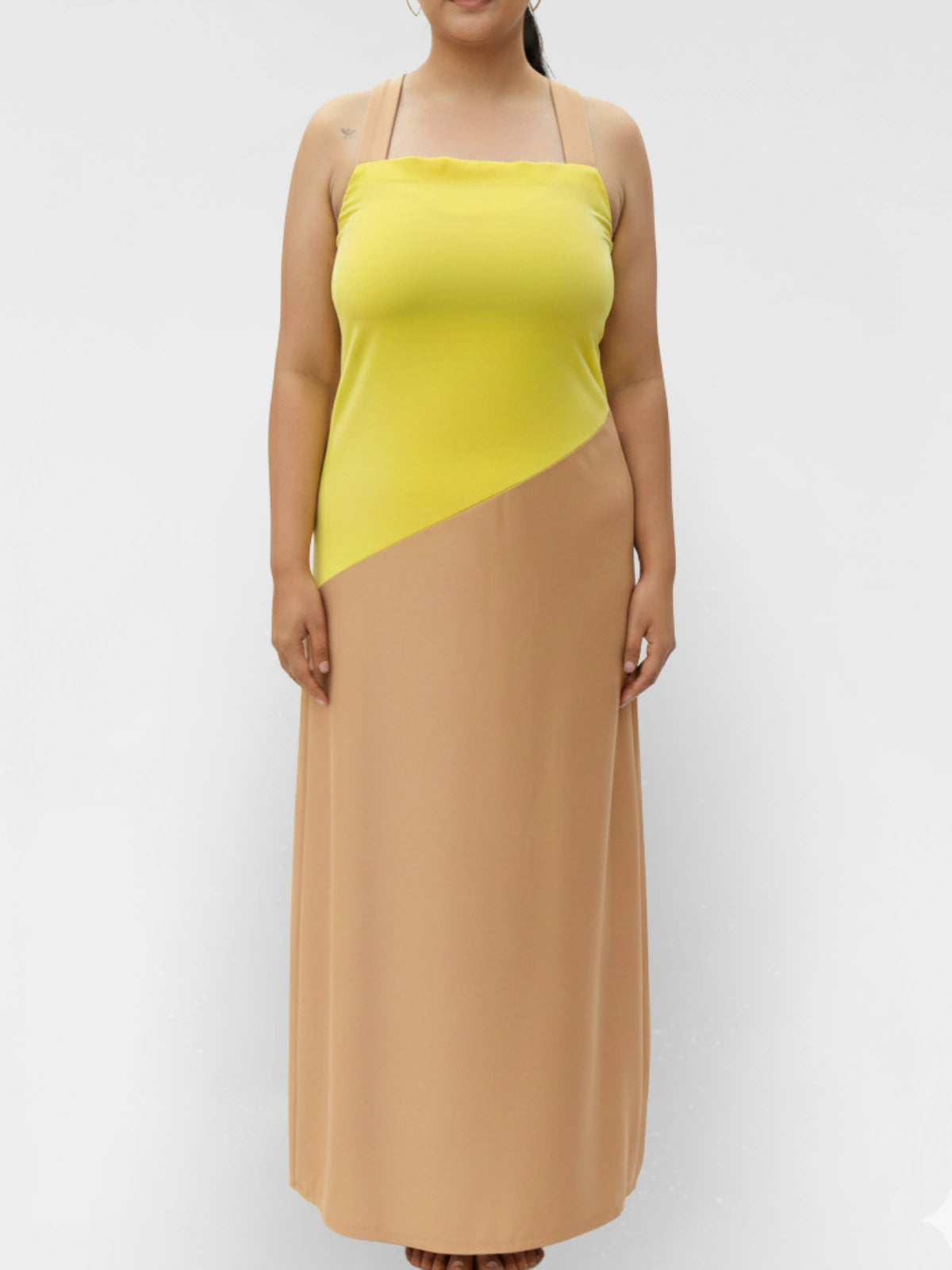 Woman wearing a two-tone dress with yellow top and brown bottom on a white background
